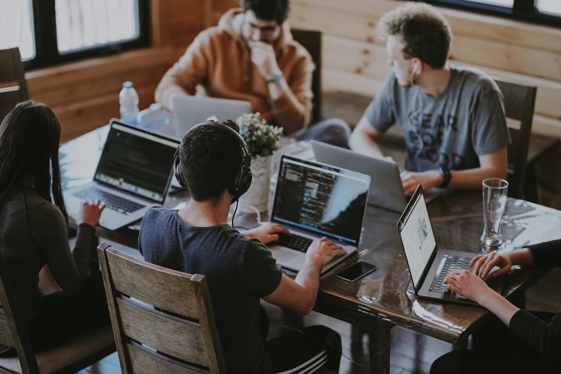 Pessoas trabalhando juntas com computadores em uma mesa